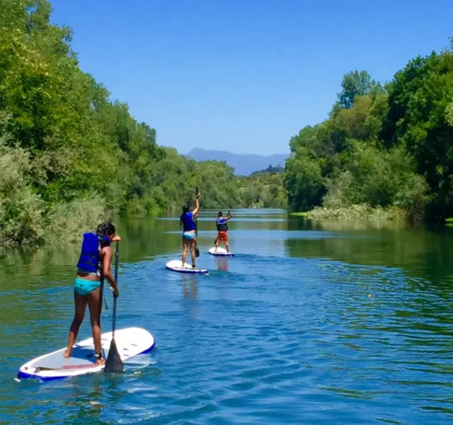 Three persons on a paddleboard tour