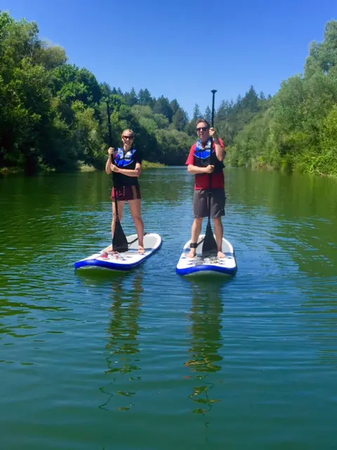 Man and woman standing on paddleboards