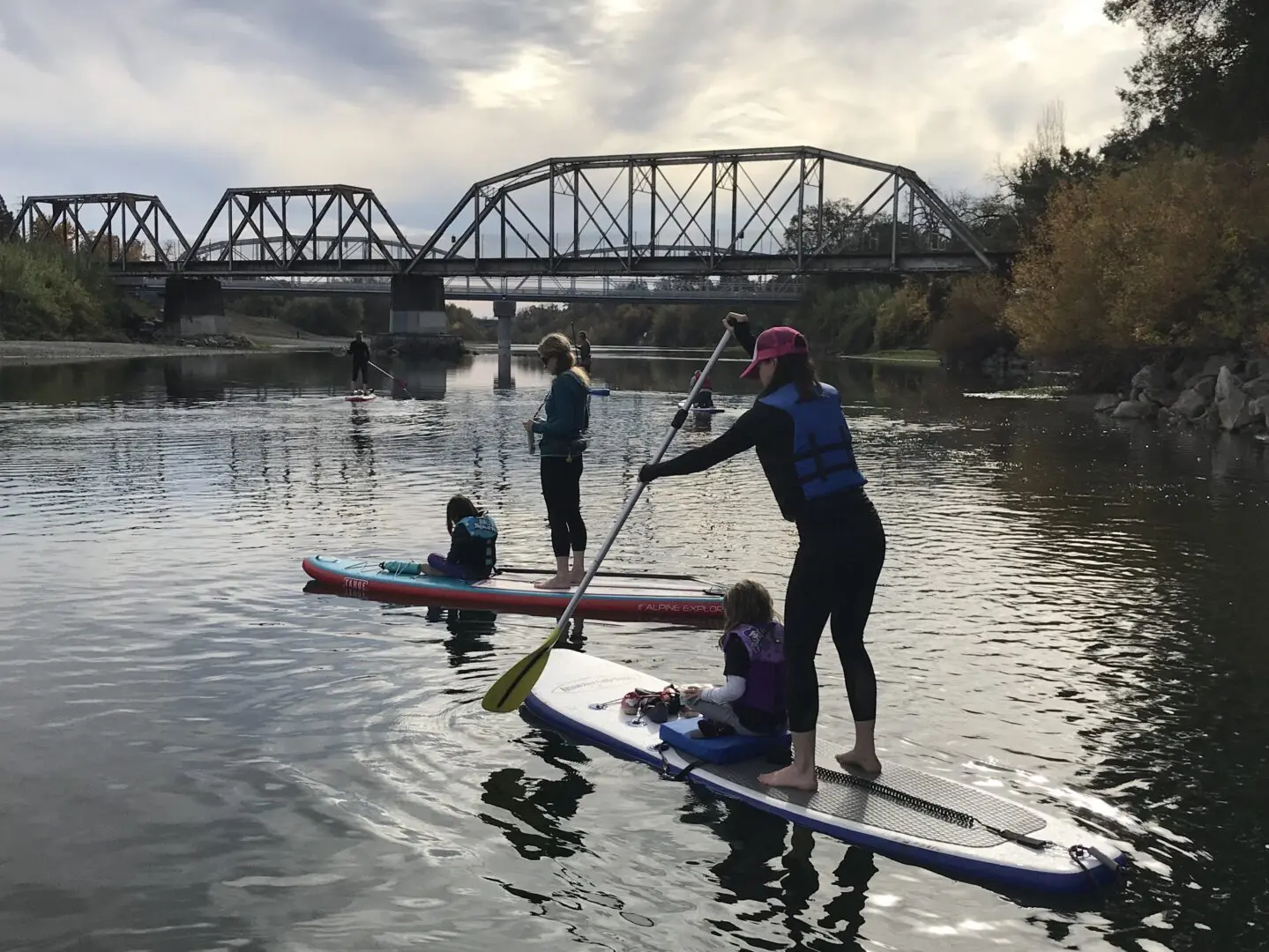 Two pairs of kids and adults paddleboarding