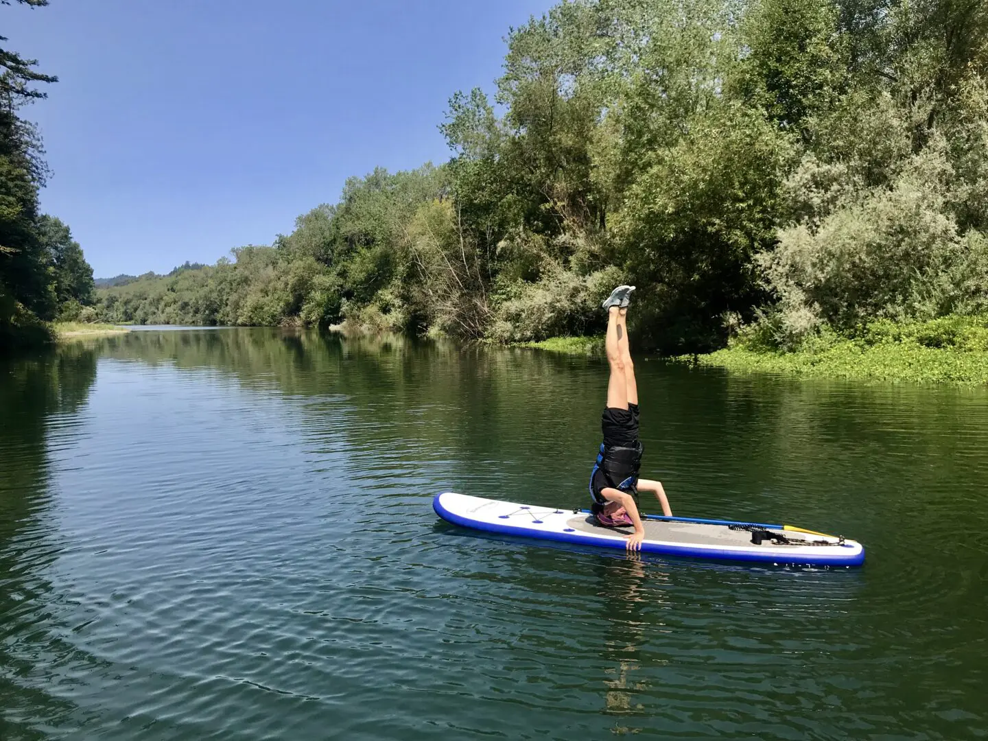 Person standing upside down on a paddleboard